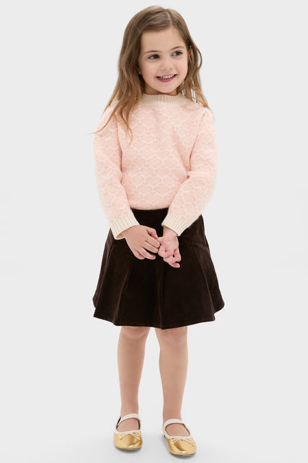 Young girl wearing the Girls Pleated Corduroy Skirt, styled with a classic, effortless look. The skirt, perfect for special occasions, embodies high-end, fun fashion.