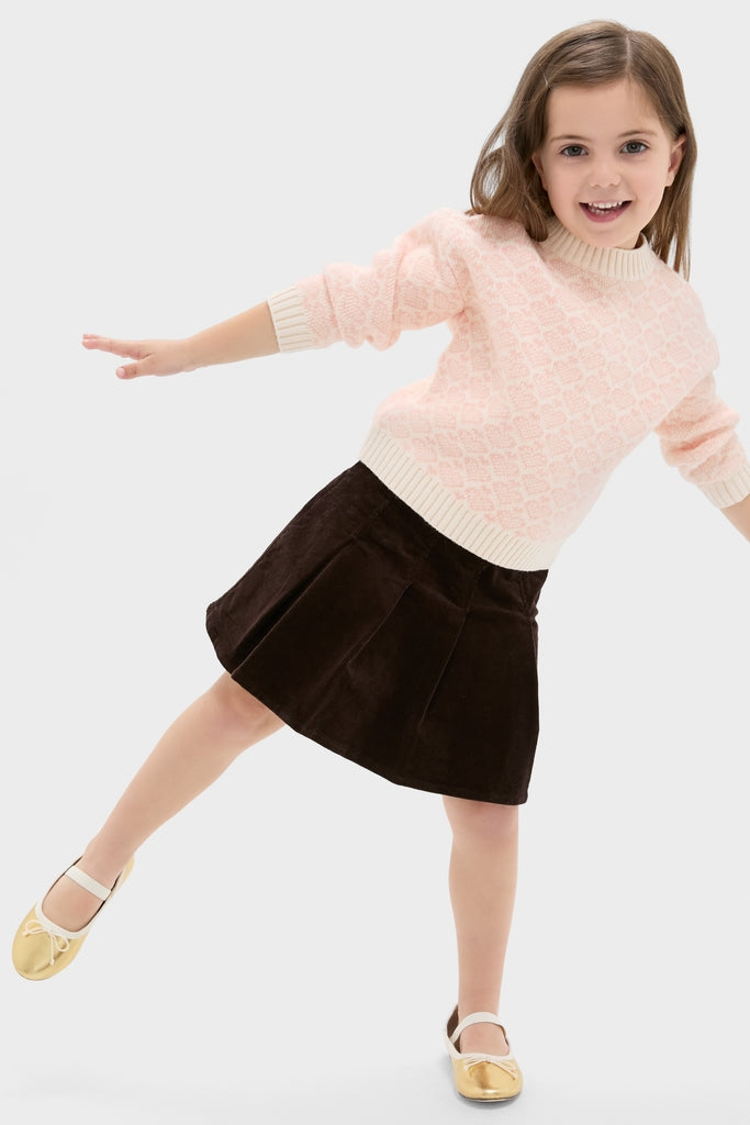 Young girl joyfully poses in a classic, fun Girls Pleated Corduroy Skirt, embodying effortless style and high-end craftsmanship, perfect for special moments.