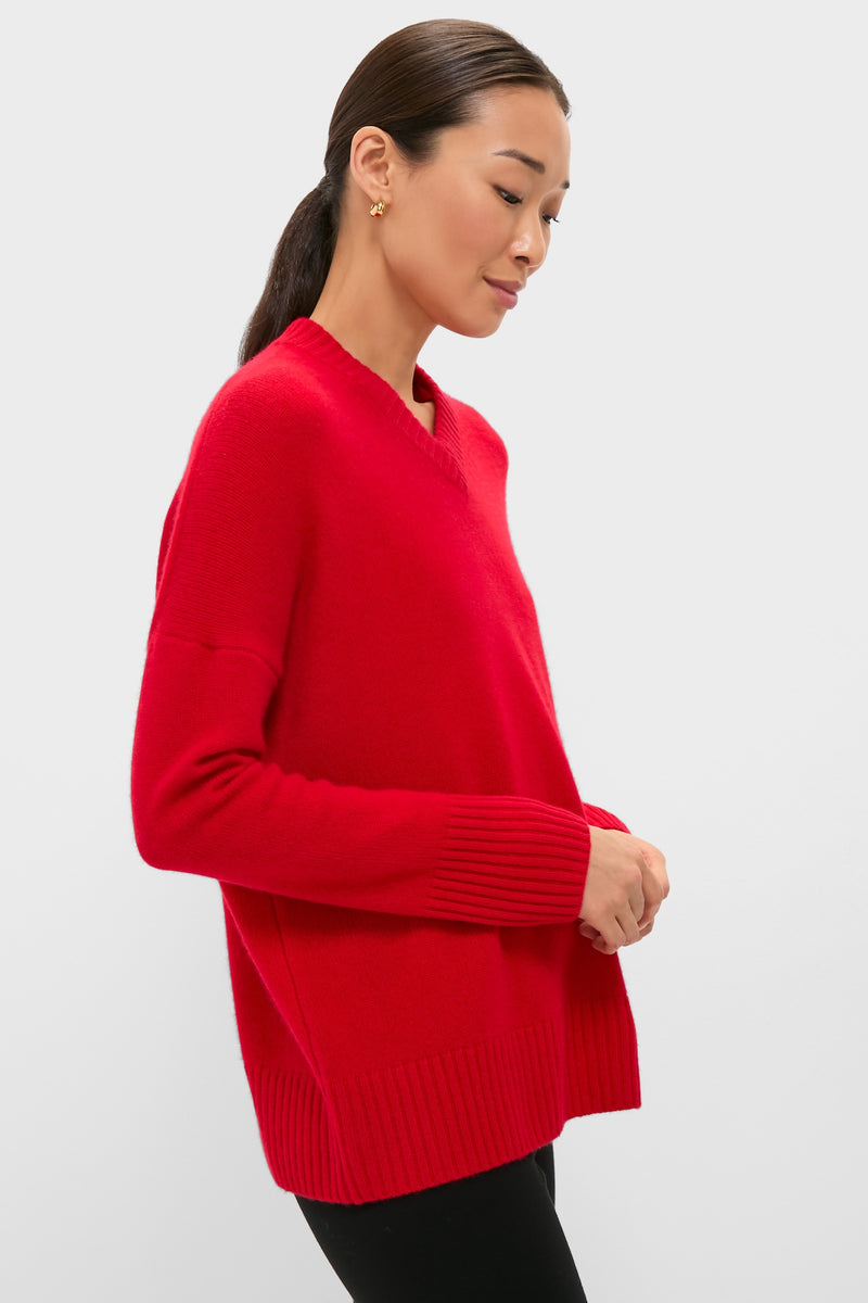 Woman in profile wearing Martin Red Cashmere Cassie V-Neck Sweater with ribbed cuffs, embodying classic, effortless style. Perfect blend of fun and high-end fashion.