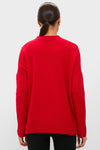 Model in a Martin Red Cashmere Cassie V-Neck Sweater, showcasing its classic, effortless style with a relaxed fit and ribbed details, epitomizing high-end comfort.