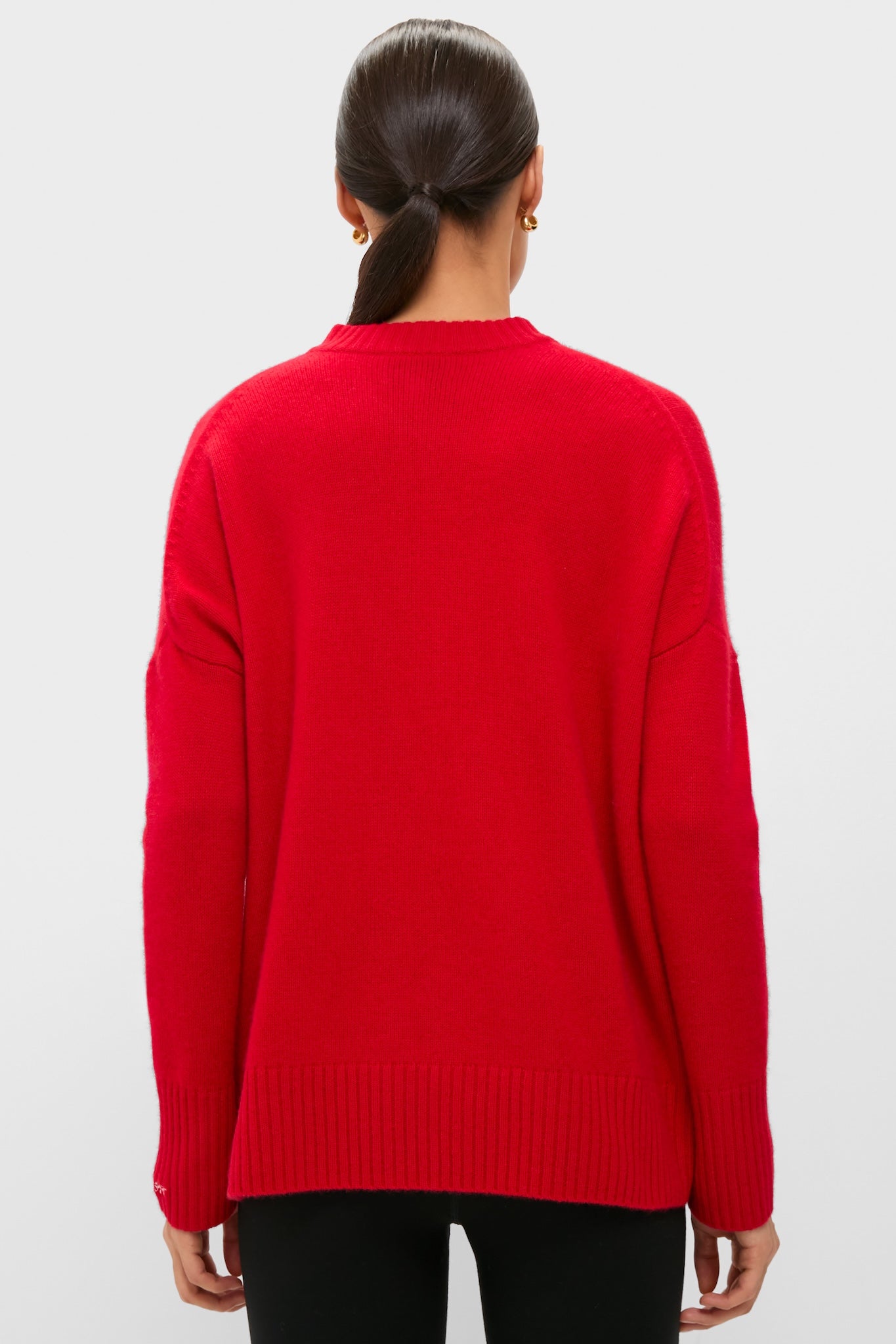 Model in a Martin Red Cashmere Cassie V-Neck Sweater, showcasing its classic, effortless style with a relaxed fit and ribbed details, epitomizing high-end comfort.