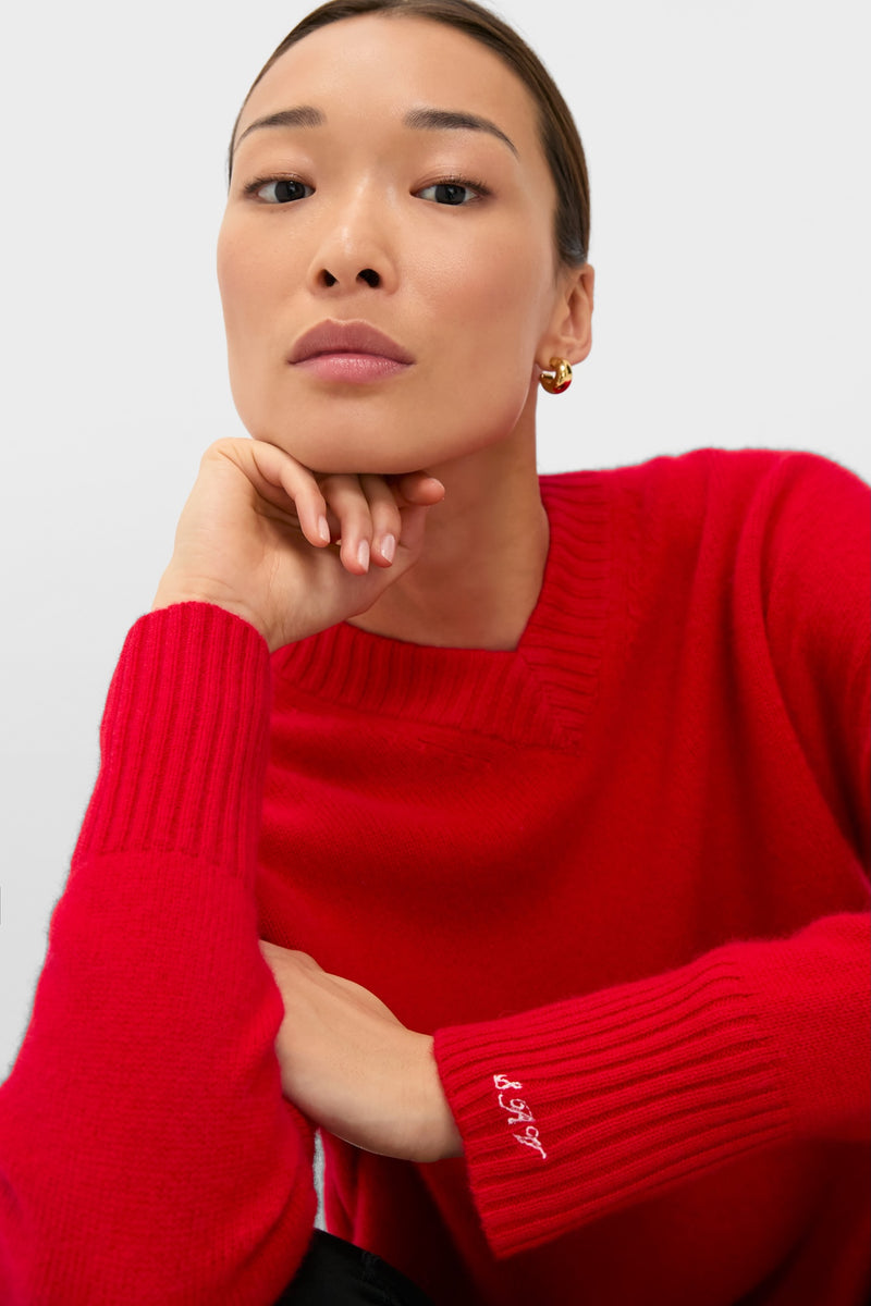 Close-up of a woman wearing the Martin Red Cashmere Cassie V-Neck Sweater, showcasing its classic, effortless design with ribbed cuffs and a relaxed fit for high-end comfort.