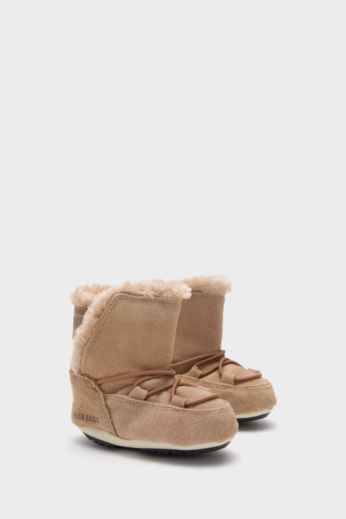Classic and effortless, the Kids Whiskey Crib Suede Boots feature tan suede with faux-fur lining, moccasin stitching, and leather laces, perfect for a fun, high-end winter look.