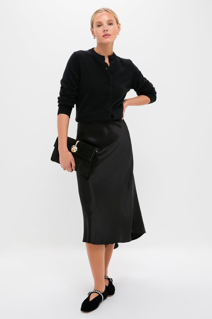 Model showcases Black Stella Slippers, a classic ballet flat with an embellished ankle strap. Effortlessly high-end, these shoes blend fun and elegance for any occasion.