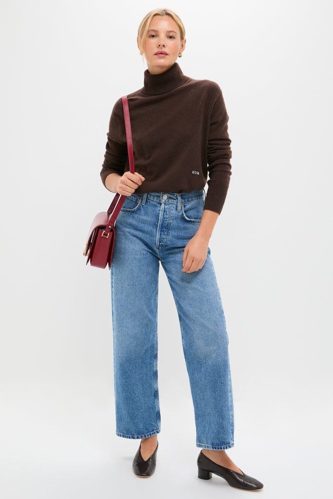 Young woman in classic style wearing Printed Python Luna Pumps, paired with jeans and turtleneck, showcasing effortless, high-end fashion with a fun, adventurous flair.