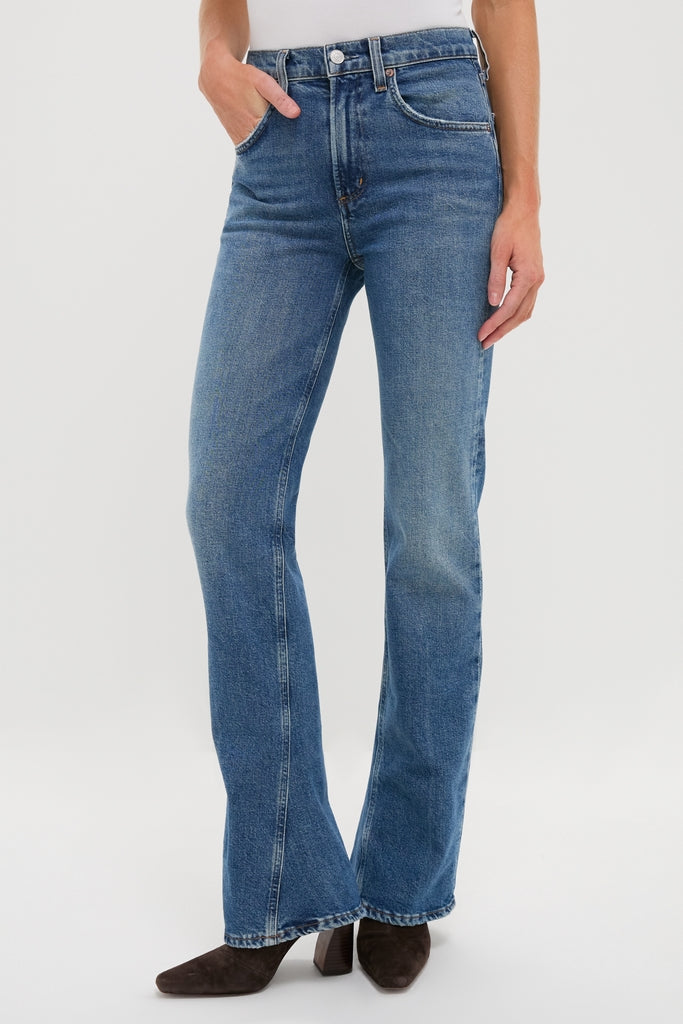 Curve Mid Rise Kick Boot jeans showcase a classic, effortless style with a subtle flare, paired with dark brown ankle boots for a high-end, fun look.