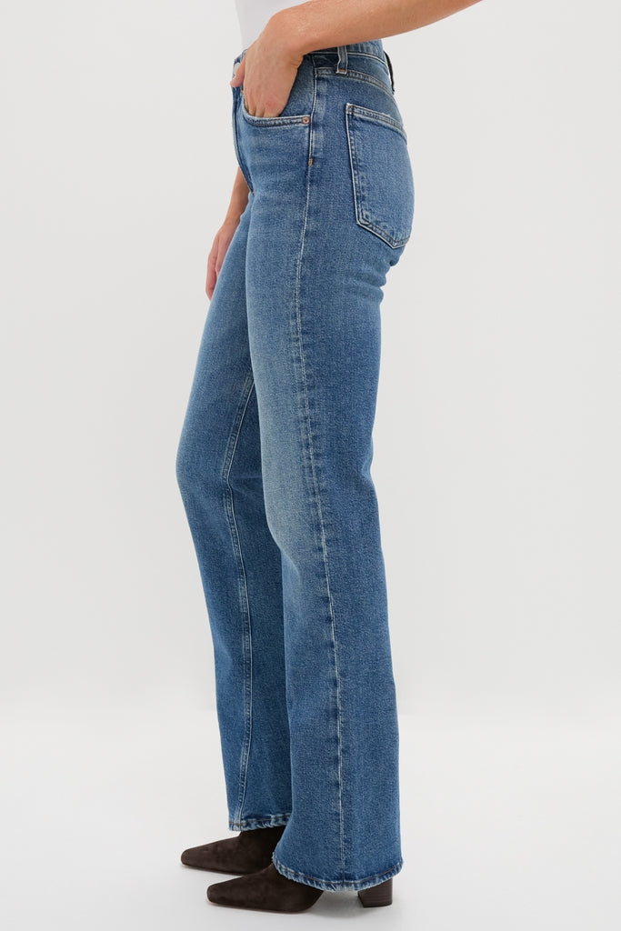 Curve Mid Rise Kick Boot jeans in medium-wash denim, featuring a classic, effortless bootcut silhouette. Paired with dark ankle boots for a fun, high-end look.