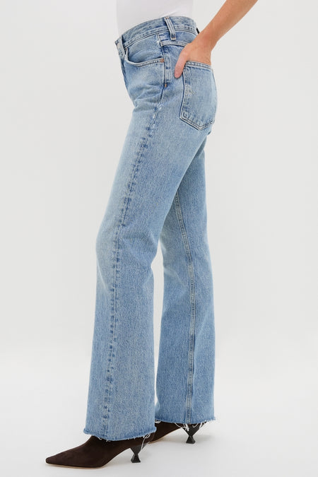 Model wearing Stage Leena Jean, a classic high-rise, baby flare denim with raw hem, paired with chic, pointed-toe boots for an effortless, high-end style.