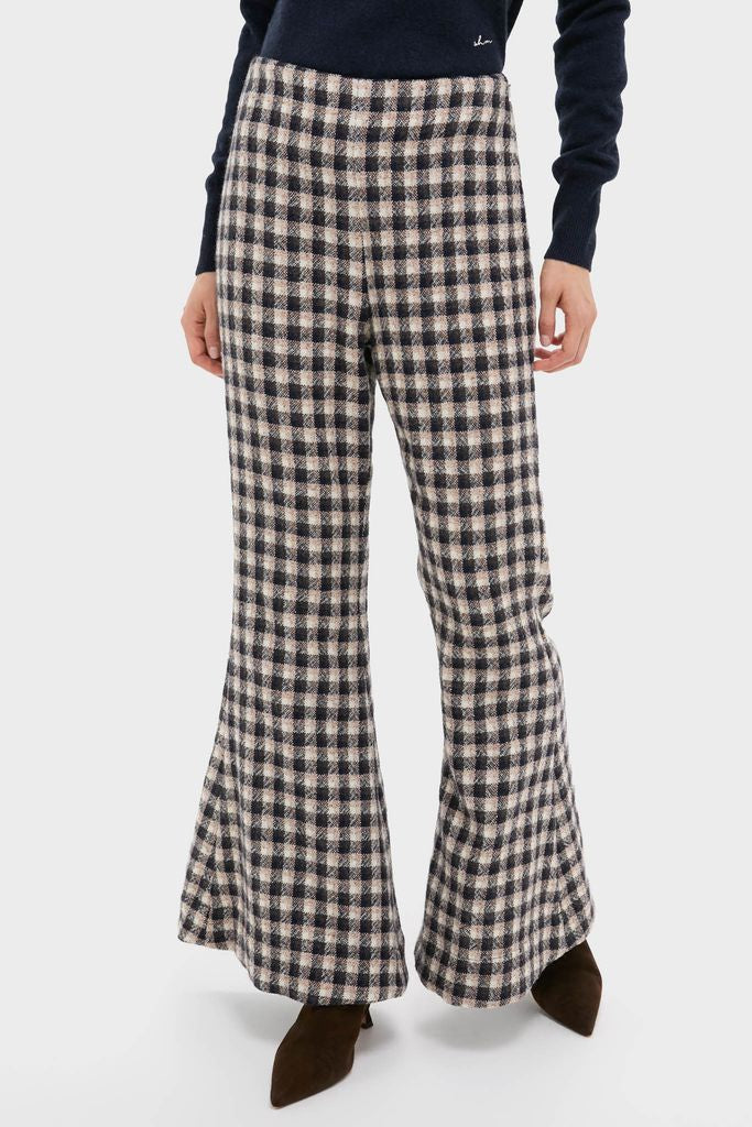 Nude Trail Farah Dust Pant showcases a classic, high-waisted, wide-leg flare design in a black-and-cream checkered pattern, paired with dark, pointed-toe ankle boots for an effortless, high-end look.