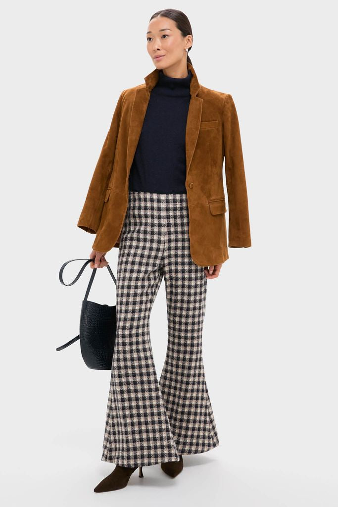 Woman models the Nude Trail Farah Dust Pant, a high-waisted check pattern piece, paired with a classic navy turtleneck and camel blazer, exuding effortless, high-end style.