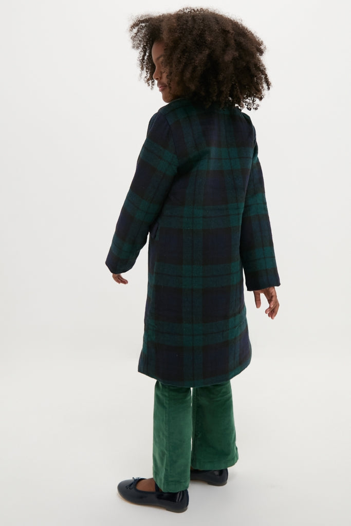 Child in a classic Blackwatch Velvet Trim Coat, showcasing effortless style with plaid pattern, velvet details, and fabric-covered buttons, embodying a high-end, fun fashion statement.