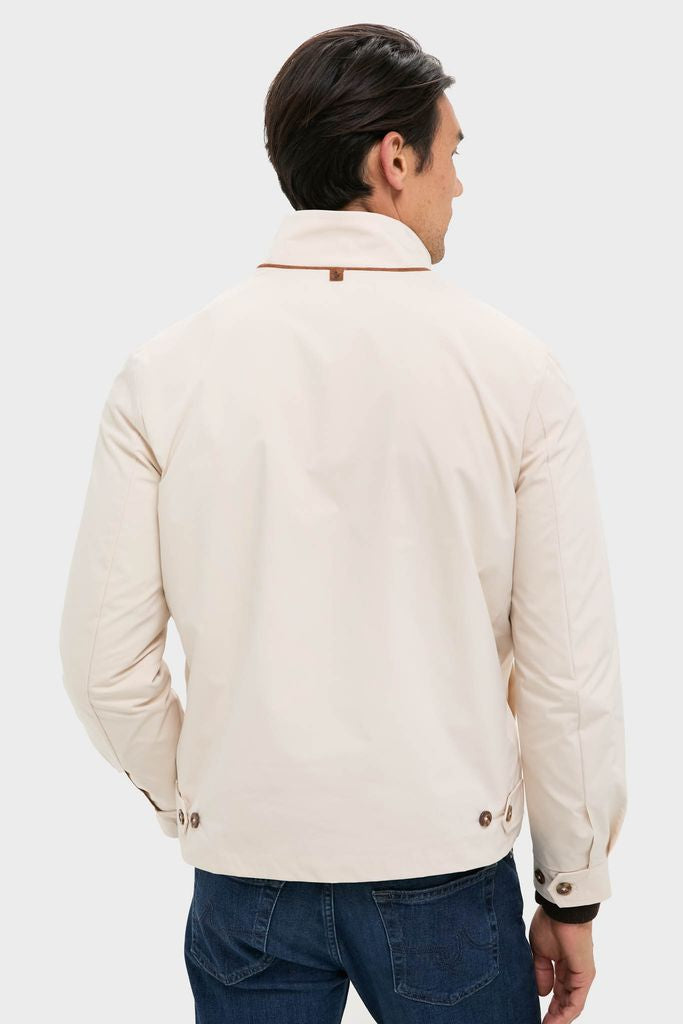 Man wearing the Tan Stanley Jacket, a classic, high-end piece with modern suede-trimmed pockets and button/tab details, styled effortlessly with jeans in a studio shot.