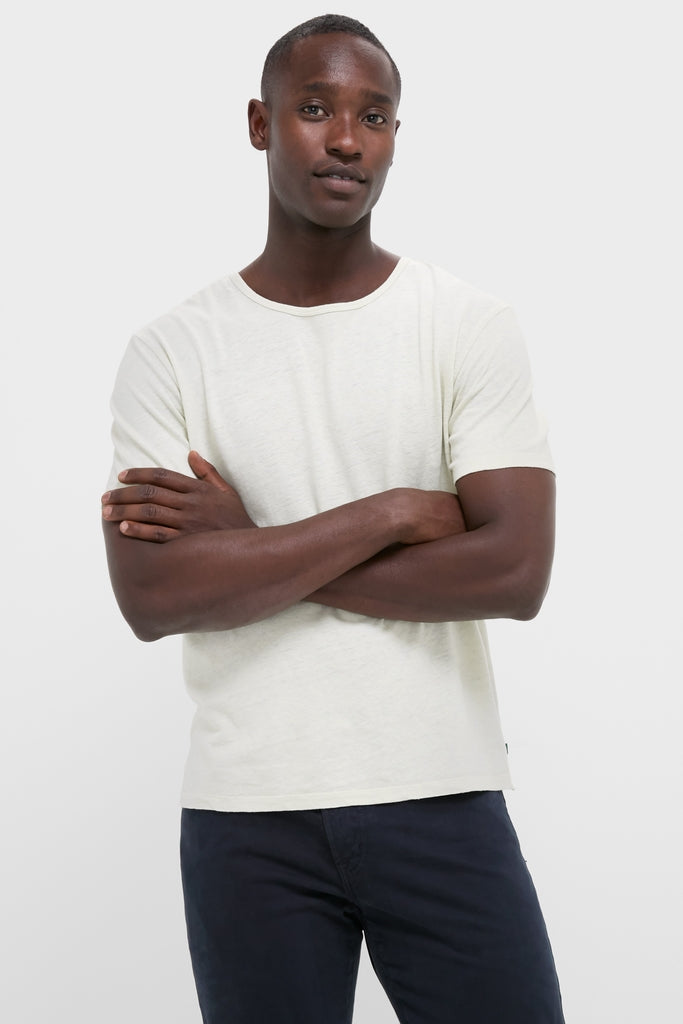 Young man wearing the Sand Drift Linen Tee, a classic, effortless off-white T-shirt with a relaxed fit, perfect for high-end, fun summer styling.