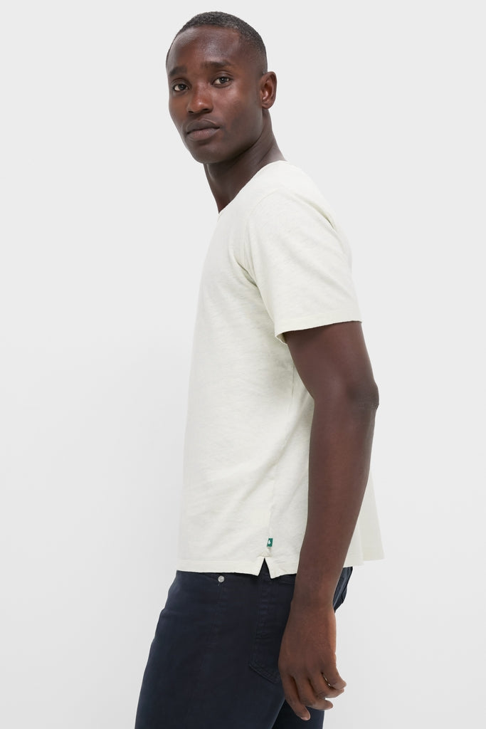Young man in profile wearing the Sand Drift Linen Tee, a classic, effortless, high-end, short-sleeve T-shirt, showcasing its relaxed fit and slightly slubbed texture.