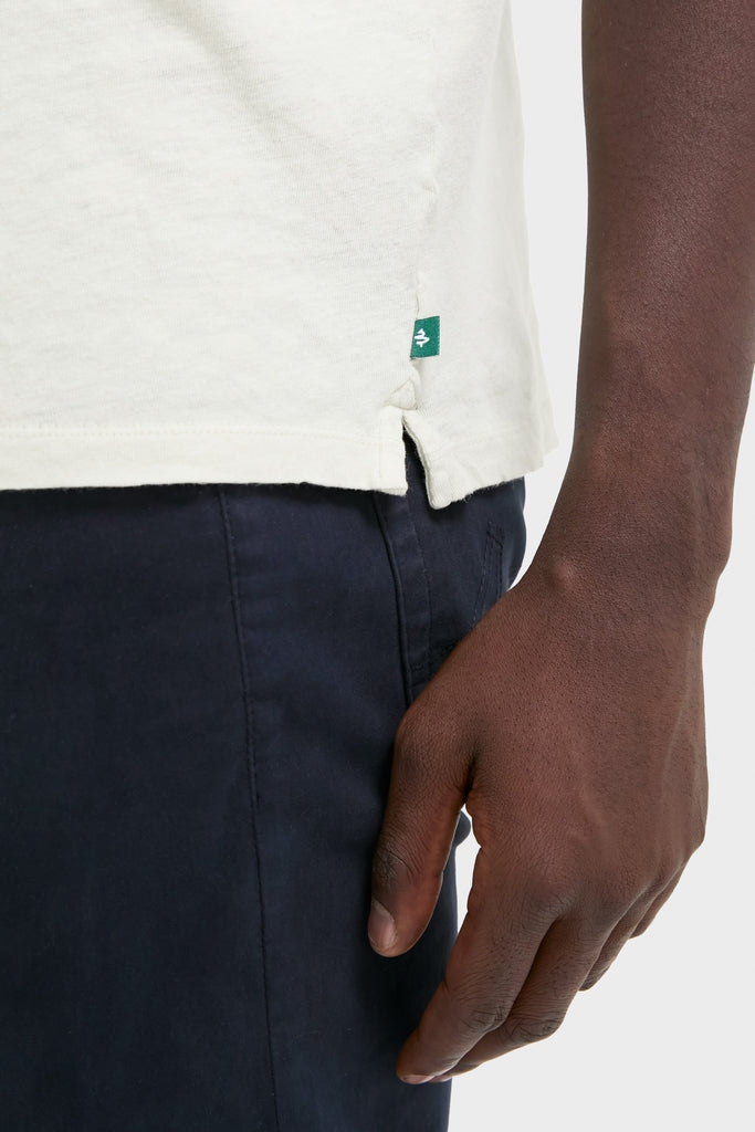 Classic Sand Drift Linen Tee with a relaxed fit and slubbed texture, effortlessly draping over navy pants. Perfect for fun, high-end summer styling.