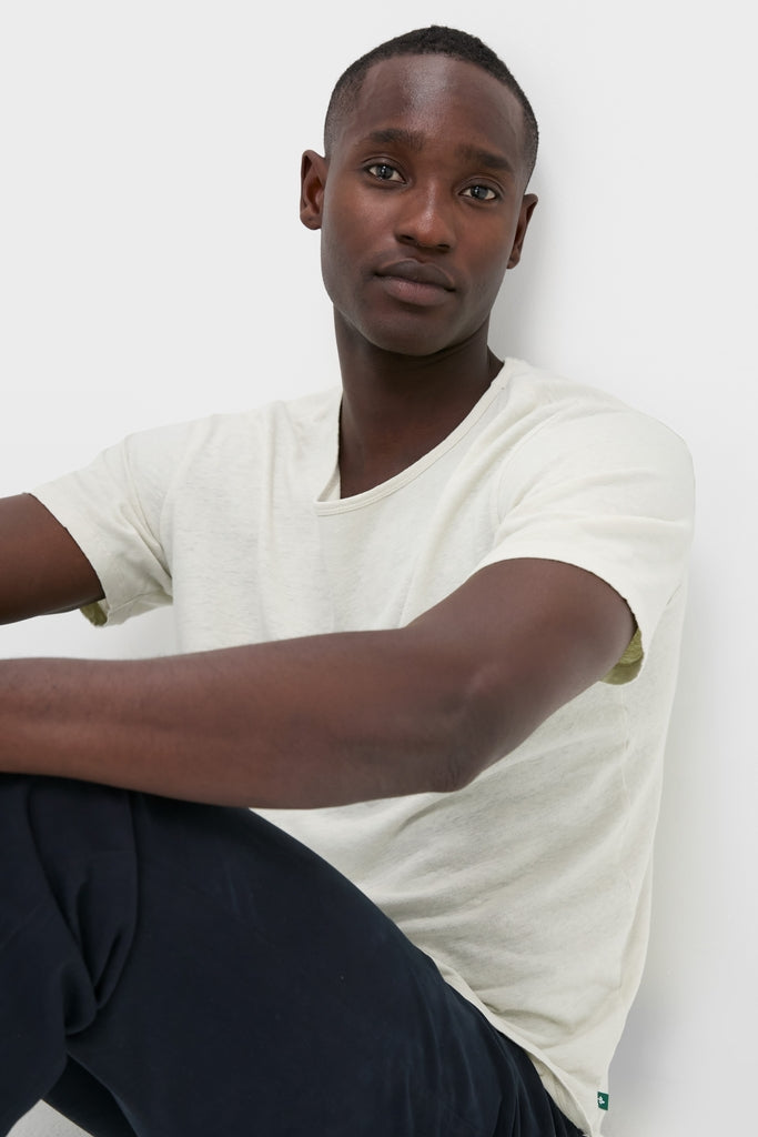 Young man wearing the Sand Drift Linen Tee, a classic, effortlessly cool shirt with a relaxed fit and slubbed texture, embodying high-end comfort and style.