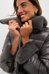 Effortlessly chic woman in a classic anthracite nylon ultralight mid-thigh jacket with plush faux fur collar, exuding high-end style and fun sophistication.