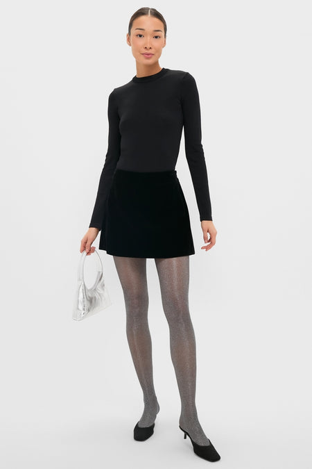 Model wearing classic black and silver glitter tights, paired with a fitted top and A-line skirt, exuding an effortless, high-end, and fun style.