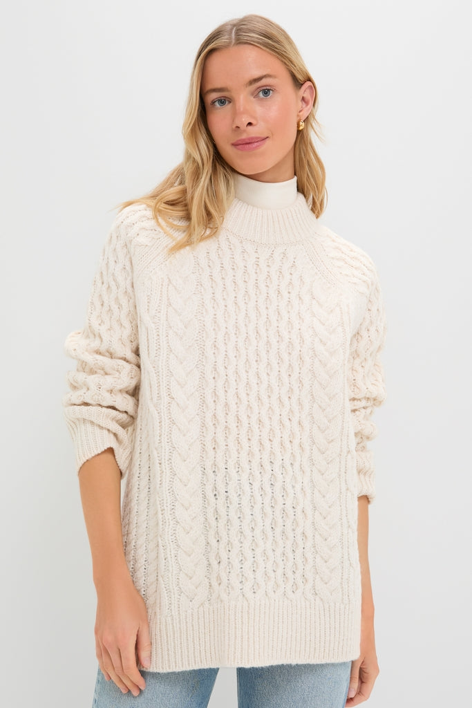 Ivory Galway Fisherman Sweater modeled; classic cable-knit, high mock neck, ribbed cuffs. Effortless and fun style with a high-end feel, perfect for cooler weather.