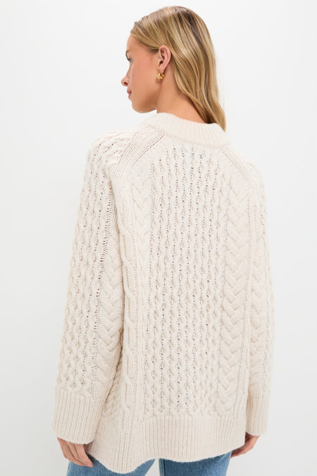 Person wearing the Ivory Galway Fisherman Sweater; a classic, cable-knit design with a relaxed fit, showcasing effortless, high-end style with ribbed collar, cuffs, and hem.
