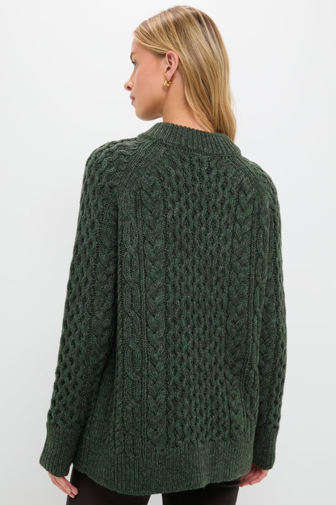 Back view of a woman wearing the classic Hunter Green Galway Fisherman Sweater, showcasing effortless, high-end cable-knit design with a relaxed fit and ribbed finishes.