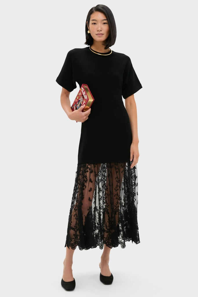 Model holding Bordeaux The Nutcracker Book Clutch, a classic, high-end, hand-embroidered accessory, embodying an effortless blend of fun and elegance with a unique floral lace dress.