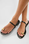 Black Kibera Sandals: Classic black leather slides with gold-tone toe loop accents, offering an effortless, high-end look perfect for fun, versatile styling.