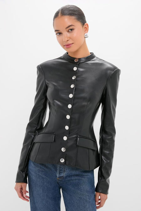Model wearing the Black Vegan Leather Military Jacket with a high collar, silver snap-buttons, and princess seams, paired with blue jeans for a classic, effortless, high-end look.