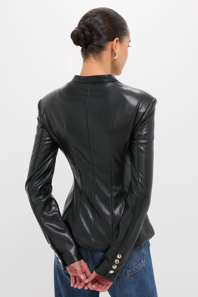 Person in a classic Black Vegan Leather Military Jacket with waist panel stitching and silver-tone buttons, paired with medium-wash jeans, exuding effortless, high-end style.