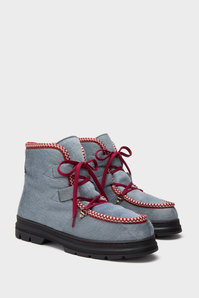 Mist Incredible Pony Shearling-Lined Boots feature a classic design with a light steely-blue fur-textured upper, red-and-white trim, and burgundy laces on a chunky lug sole.