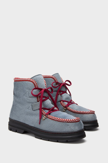 Mist Incredible Pony Shearling-Lined Boots feature a classic design with a light steely-blue fur-textured upper, red-and-white trim, and burgundy laces on a chunky lug sole.