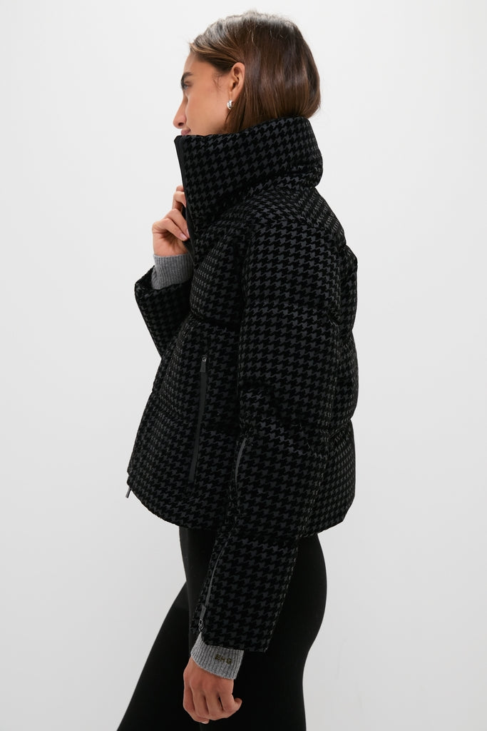 Woman in classic Black Tech Pied de Poule Short Jacket with houndstooth pattern, high collar, and zippered pockets, paired with black leggings for an effortless, high-end look.