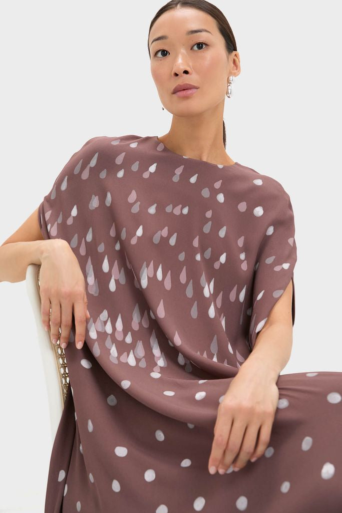 Woman in a classic, effortless Polka Rain Eleonore Dress, showcasing a high-end, fun style with a relaxed silhouette and sculptural earring. Perfect for stylish events.