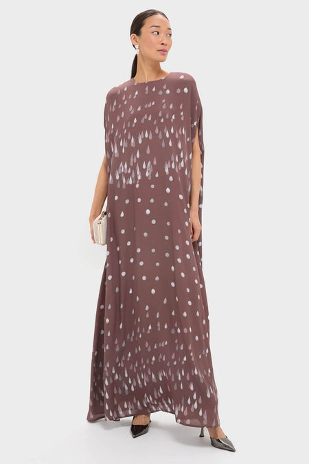 Model wearing the classic Polka Rain Eleonore Dress in deep brown, featuring an effortless silhouette with silvery raindrop motifs, paired with heels and a clutch for a high-end look.