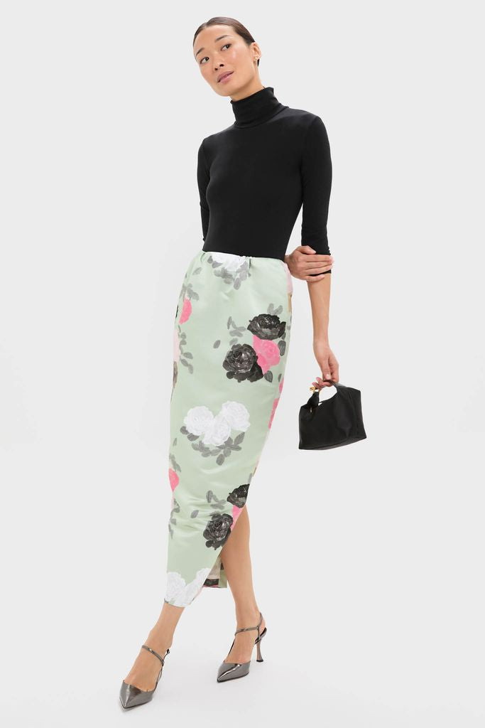 Model wearing the classic Sage Green Auscot Rose Damian Skirt, effortlessly styled with a black turtleneck, showcasing its high-end floral design and elegant pencil silhouette.