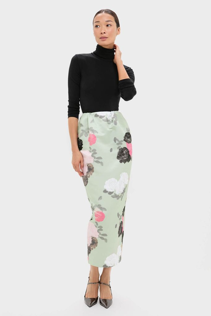 Woman models classic Sage Green Auscot Rose Damian Skirt with effortless floral print, tucked black turtleneck, and strappy heels, embodying fun, high-end style.