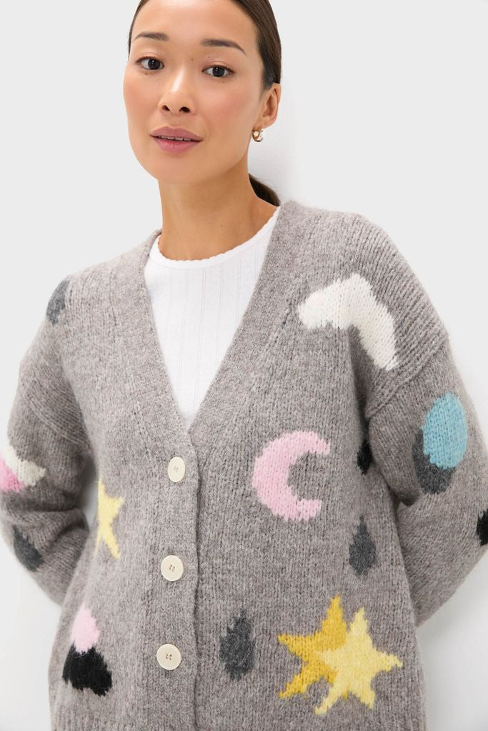 Person wearing the Grey Weather Cycles Intarsia Stormy Cardigan with whimsical pastel shapes, over a white ribbed top. A classic, effortless, and high-end piece.