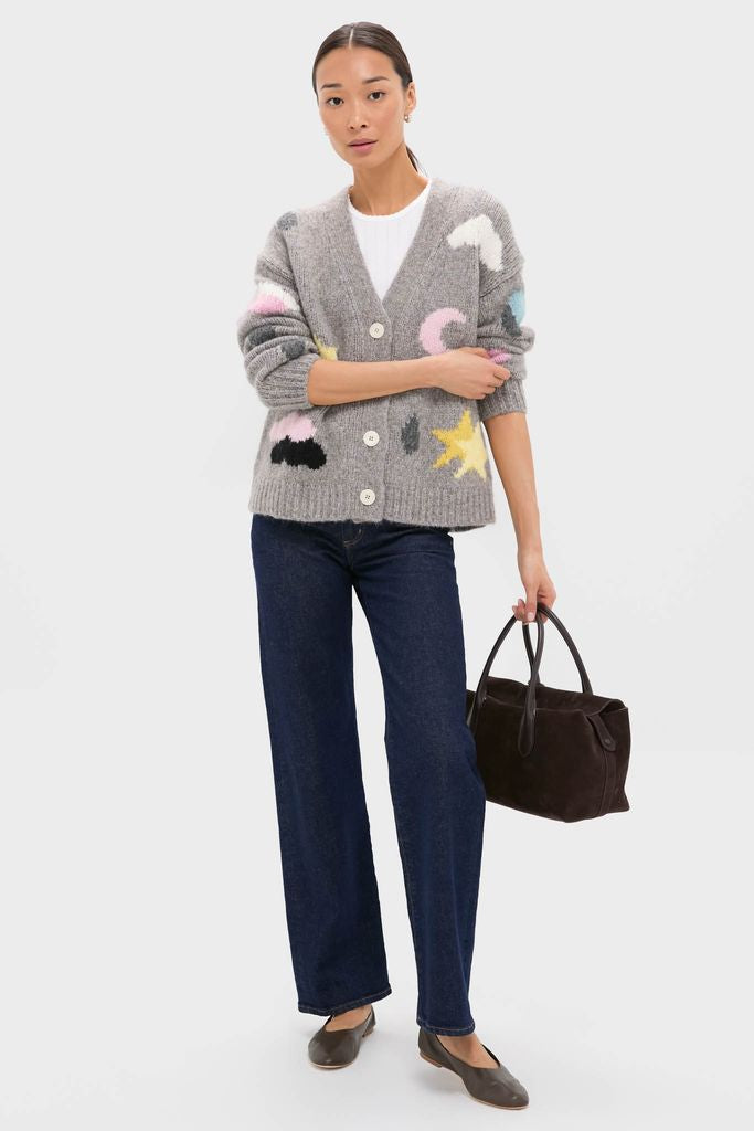Woman in a classic, effortless Grey Weather Cycles Intarsia Stormy Cardigan with abstract patches, styled with dark jeans, flats, and a tote, exuding high-end, fun sophistication.