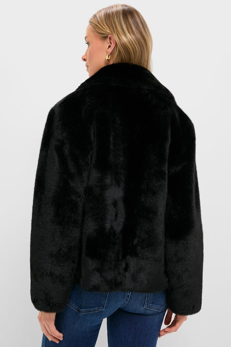 Person wearing the classic Black Faux Fur Taos Jacket with a plush, fluffy texture and oversized design, paired with blue jeans for an effortless, high-end look.