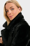 Young woman in a Black Faux Fur Taos Jacket, showcasing its high, soft collar and plush texture, paired with a small gold hoop earring for an effortless, high-end look.