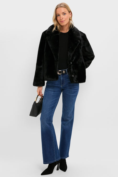 Young woman wearing the classic Black Faux Fur Taos Jacket, paired with jeans and ankle boots, exuding an effortless, high-end style with a fun, confident flair.