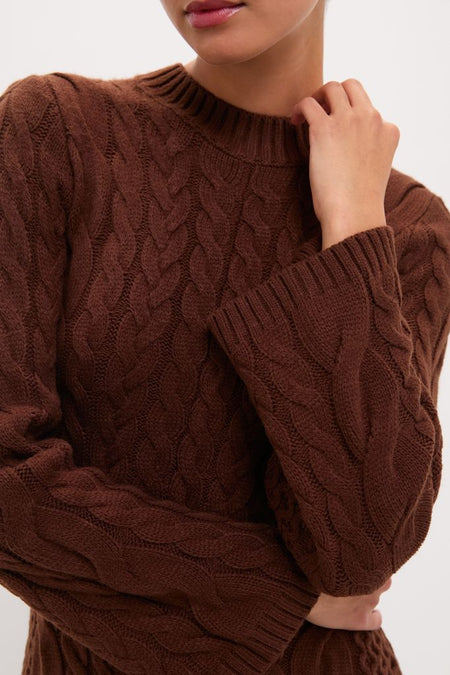 Close-up of a classic, rich brown Chocolate Cable Knit Fernie Midi Dress with an effortless braided pattern and ribbed crew neckline, exuding a fun, high-end style.