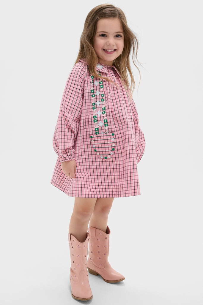 Girl in Pink Check Gatsby Dress with floral embroidery and light-pink cowboy boots, embodying classic, effortless style. Perfect for a fun, high-end, and playful fall look.