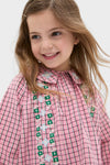 Young girl in a Pink Check Gatsby Dress with floral embroidery, ruffled collar, and pockets, exemplifying classic, effortless style by Hello Simone.