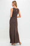 Model in a classic Chocolate Serine Maxi Dress with a keyhole back, side slit, gold hoop earrings, and nude strappy heels, embodying effortless, high-end style.