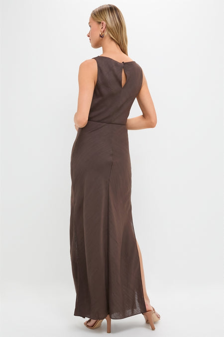 Model in a classic Chocolate Serine Maxi Dress with a keyhole back, side slit, gold hoop earrings, and nude strappy heels, embodying effortless, high-end style.