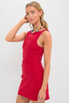 Young woman in a classic, high-end, sleeveless Vermillion Lotta Mini Dress, exuding effortless style with a fun, multicolored beaded necklace, embodying Tuckernuck's cool confidence.