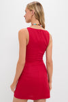 Model wearing the Vermillion Lotta Mini Dress, a classic, sleeveless, fitted red dress; accessorized with colorful beads and gold hoops, embodying effortless, high-end fashion.