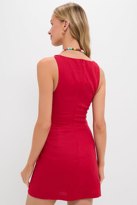 Model wearing the Vermillion Lotta Mini Dress, a classic, sleeveless, fitted red dress; accessorized with colorful beads and gold hoops, embodying effortless, high-end fashion.