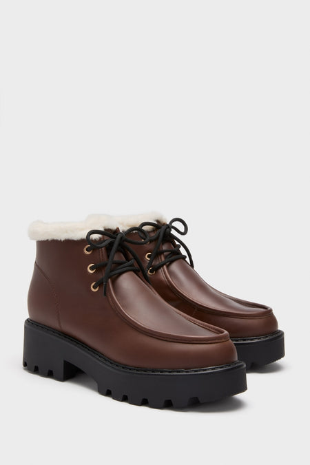 Dark Brown Percy Boots in smooth leather with faux-shearling trim, featuring a classic lace-up style, effortless lug sole, and fun gold-tone eyelets for a high-end look.